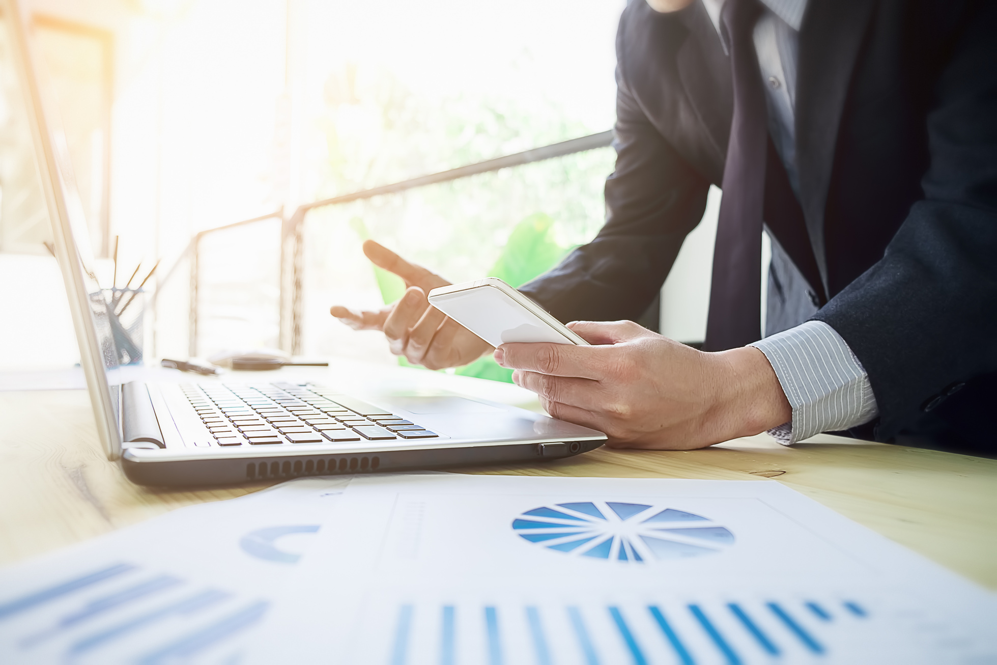 Close Up of Person with Smartphone and Graphs